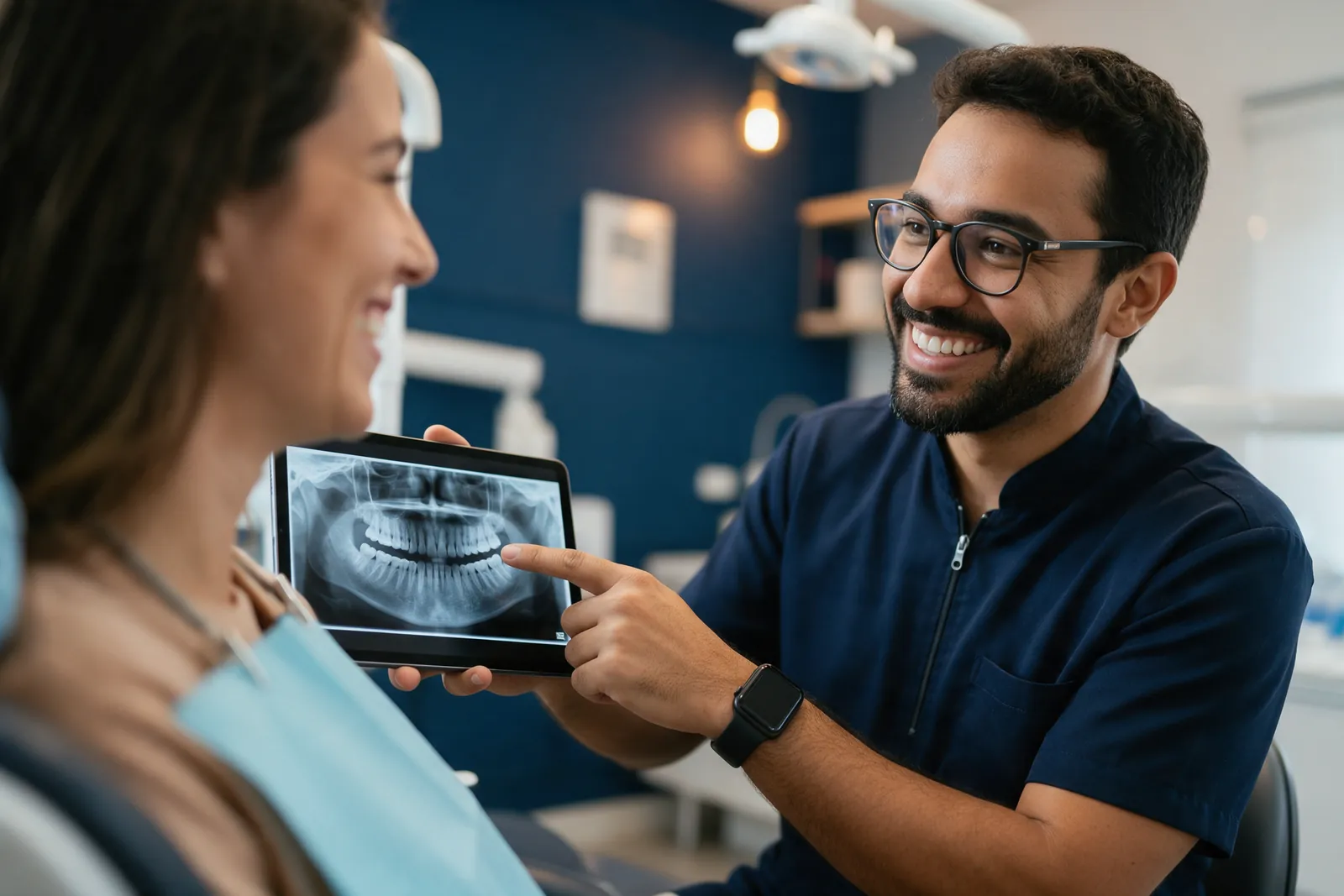 Dentista mostrando uma radiografia em um tablet para uma paciente sorridente